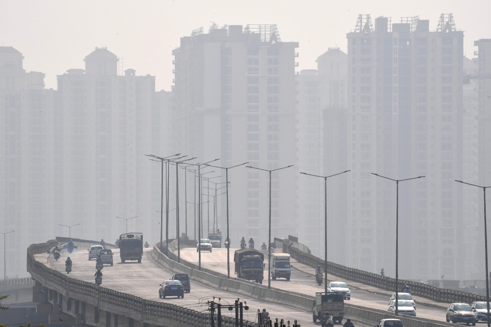 Commuters drive along a bridge under heavy smoggy conditions in Ghaziabad on November 12, 2020. / AFP / Prakash SINGH