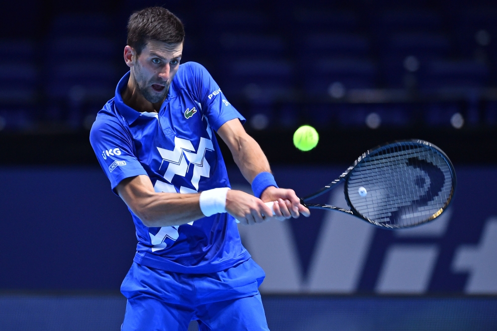 Serbia's Novak Djokovic returns against Argentina's Diego Schwartzman in their men's singles round-robin match on day two of the ATP World Tour Finals tennis tournament at the O2 Arena in London on November 16, 2020. / AFP / Glyn KIRK