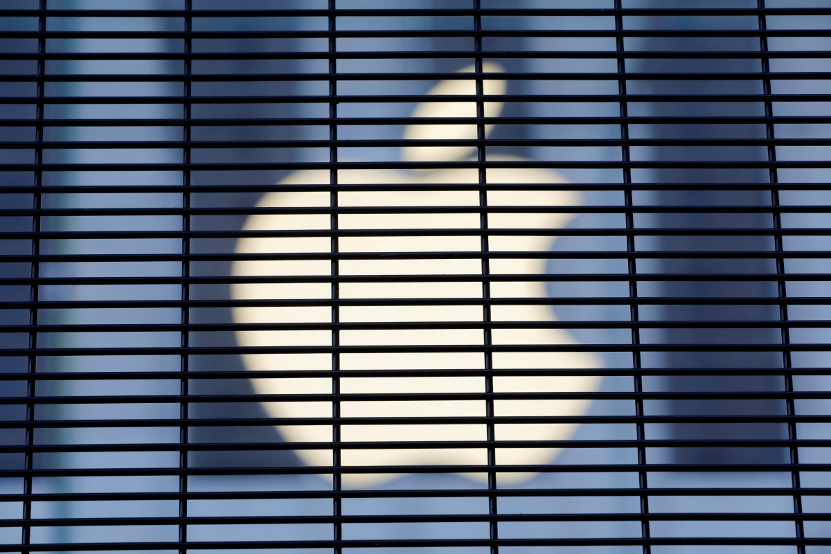 FILE PHOTO: The Apple logo is seen through a security fence erected around the Apple Fifth Avenue store as votes continue to be counted following the 2020 U.S. presidential election, in Manhattan, New York City, U.S., November 5, 2020. REUTERS/Andrew Kell
