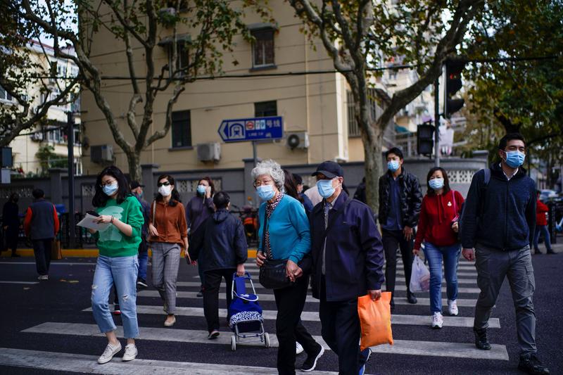 FILE PHOTO: People wearing face masks are seen on a street amid the global outbreak of the coronavirus disease (COVID-19) in Shanghai, China, November 18, 2020. REUTERS/Aly Song
