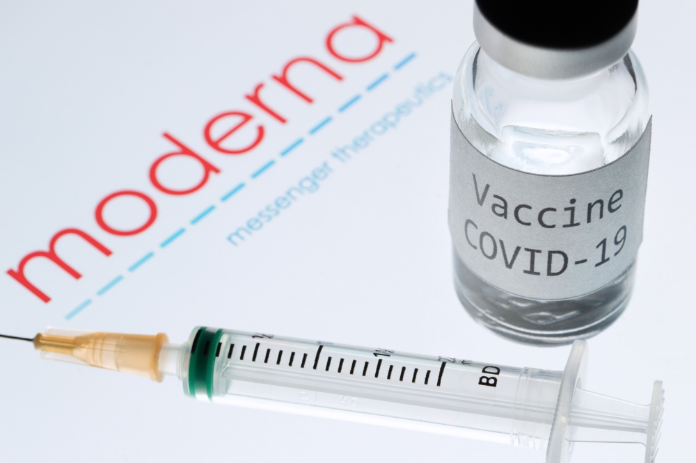 This picture taken on November 18, 2020 shows a syringe and a bottle reading 