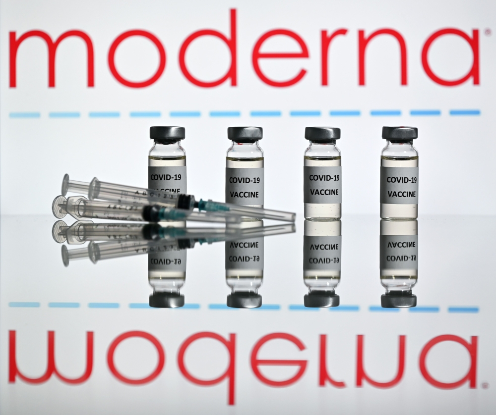 This illustration picture taken on November 17, 2020 shows vials with Covid-19 Vaccine stickers attached and syringes with the logo of US biotechnology company Moderna on November 17, 2020. The European Union said on November 24, 2020 it would sign a sixt