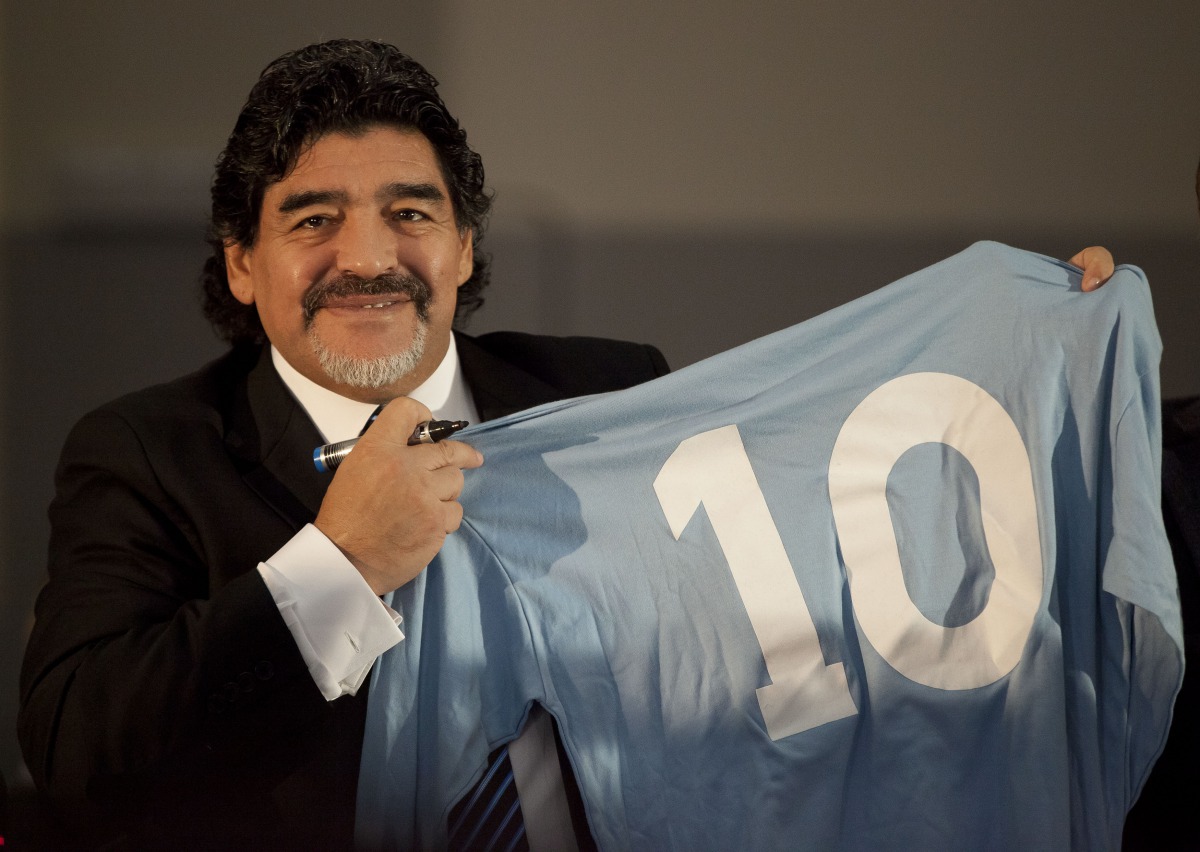 (FILES) In this file photo taken on February 26, 2013 Football legend Argentinian Diego Maradona holds a SSC Napoli number 10 jersey during a press conference in Naples. Argentinian football legend Diego Maradona passed away on November 25, 2020. / AFP / 