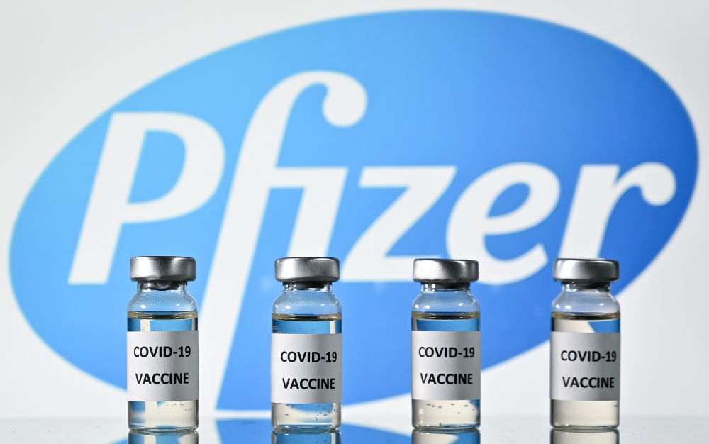 In this file photo taken on November 17, 2020 (FILES) This file photo illustration picture shows vials with Covid-19 Vaccine stickers attached, with the logo of US pharmaceutical company Pfizer, on November 17, 2020. Britain on December 2, 2020 became the