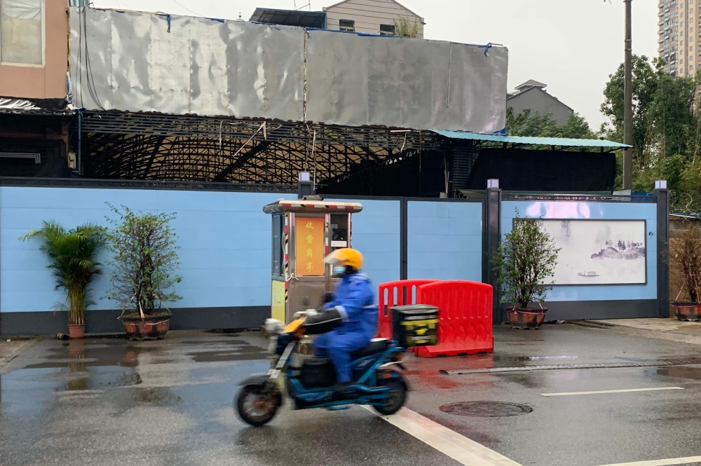 In this photo taken on November 24, 2020, a man wearing face mask as a preventive measure against the Covid-19 coronavirus rides a scooter next to the Huanan Seafood Wholesale Market in Wuhan, in China’s central Hubei province. AFP / Hector Retamal 