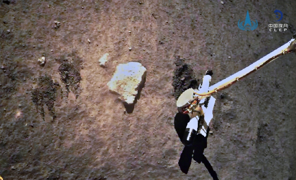 This picture taken on December 2, 2020 and released on December 3, 2020 by the China National Space Administration (CNSA) via CNS shows the Chang'e-5 lunar probe gathering samples on the moon. China OUT / AFP / China National Space Administration (CNSA) v