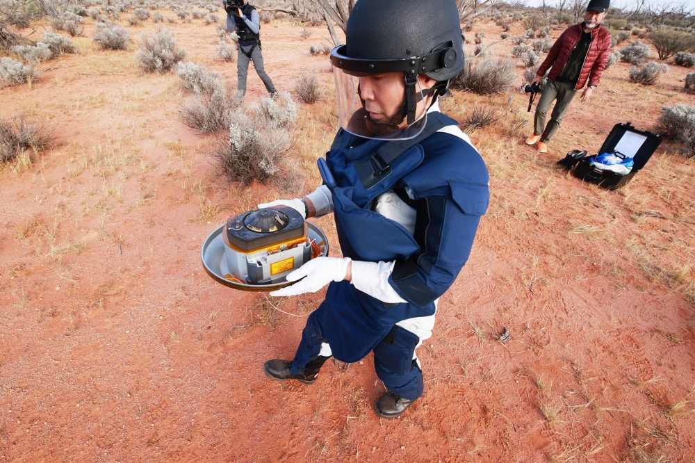 This handout photograph taken and released by the Japan Aerospace Exploration Agency (JAXA) on December 6, 2020 shows recovery operations of the re-entry capsule, carrying samples collected from a distant asteroid after being dropped off by Japanese space