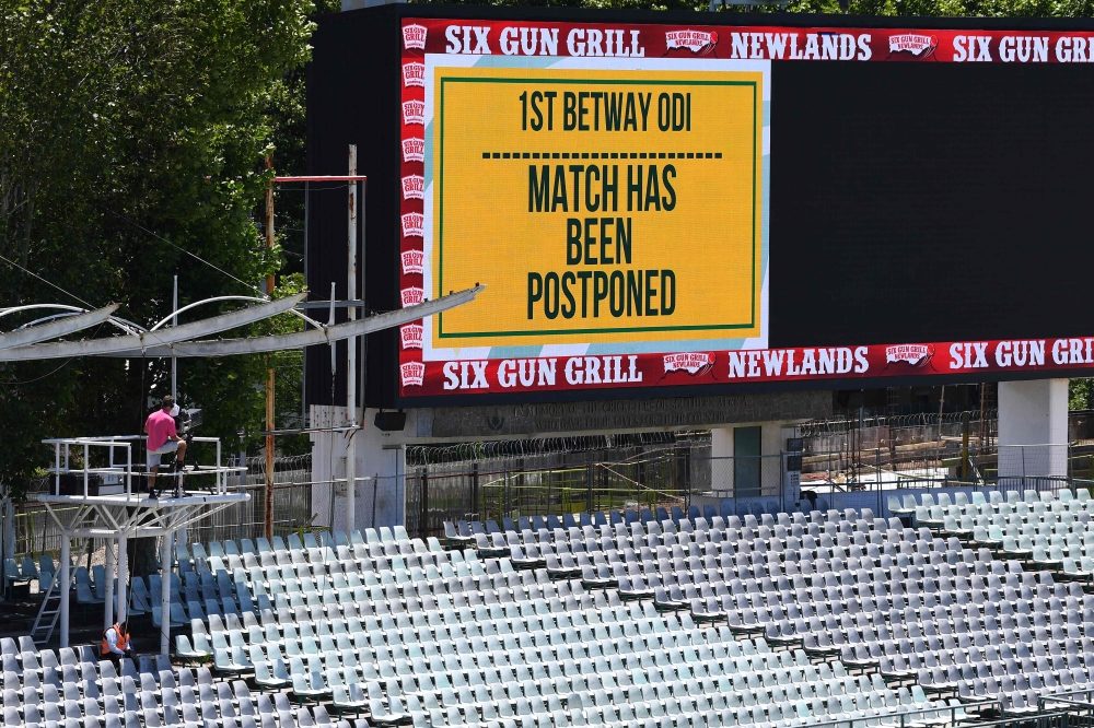 Empty stands and a message of the match postponement on the screen are seen at Newlands stadium in Cape Town, South Africa, on December 4, 2020. / AFP / Rodger BOSCH
