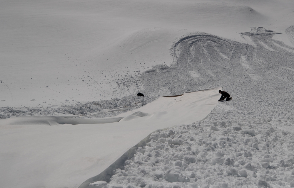 File photo: A worker adjusts a Vlies fabric to cover the snow of a glacier at Stubaier glacier ski resort near Neustift im Stubaital, Austria, May 7, 2020. Reuters/Lisi Niesner/File Photo