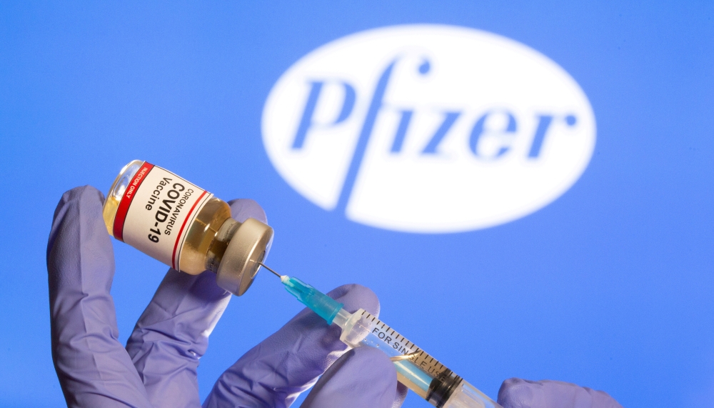 File photo: A woman holds a small bottle labeled with a 