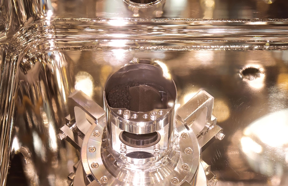 This handout photograph released by the Japan Aerospace Exploration Agency (JAXA) on December 15, 2020 shows samples of surface dust and pristine material collected from the asteroid Ryugu by the Hayabusa-2 space probe, at the JAXA Sagamihara Campus in Sa