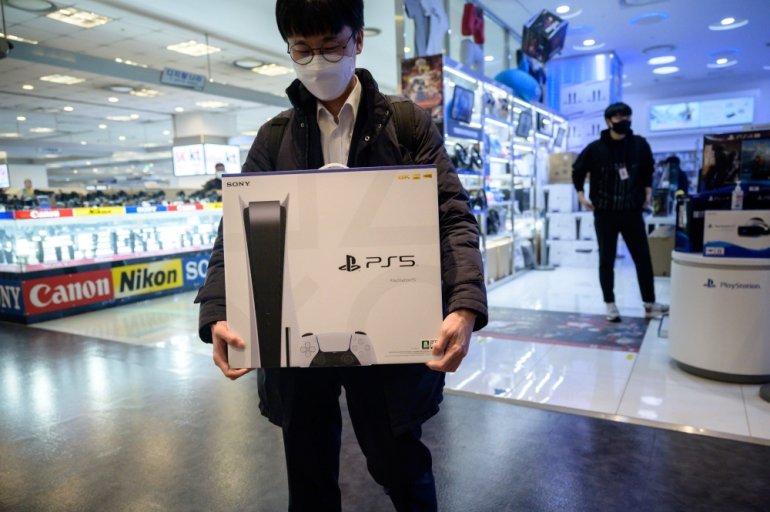 In a photo taken on November 12, 2020, a customer walks away after purchasing the new Sony Playstation PS5 in Seoul after Sony launched the new console in select markets around the world. / AFP / Ed JONES