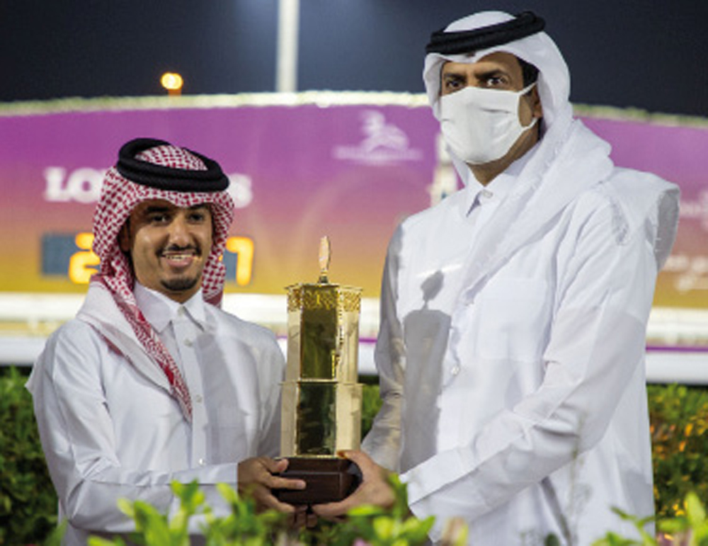 Hamad bin Abdulrahman Al Attiyah, President of Qatar and Asian Equestrian Federations, presenting the winner's trophy to team Glitter Queen's representative.