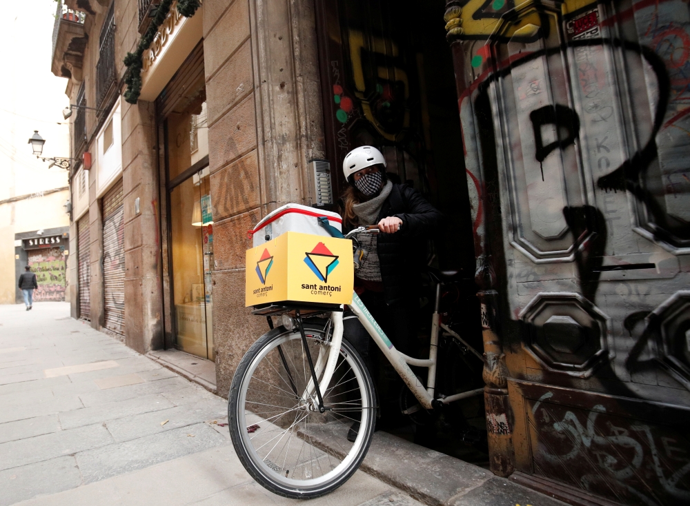 Geraldine Caillaud, member of the bicycle delivery company Les Mercedes, leaves their office with a bicycle at Barcelona's city center, during the COVID-19 pandemic, Spain, December 17, 2020. Picture taken December 17, 2020. Reuters/Albert Gea