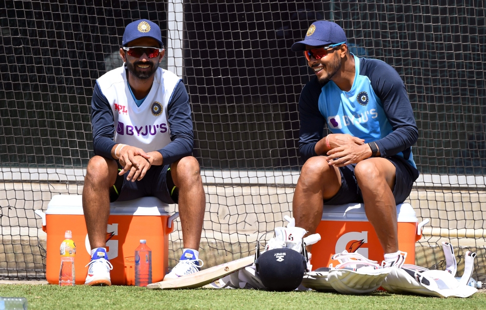 India's captain Ajinkya Rahane (L) chats with Umesh Yadav (R) during a training session ahead of the second cricket Test match against Australia, in Melbourne on December 24, 2020. AFP / William West 