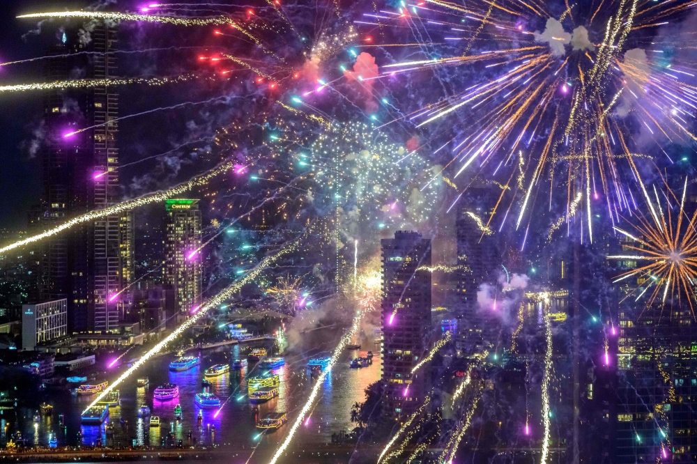New Year's Eve fireworks erupt over the Chao Phraya river during the fireworks show in Bangkok on January 1, 2021. / AFP / Mladen ANTONOV
