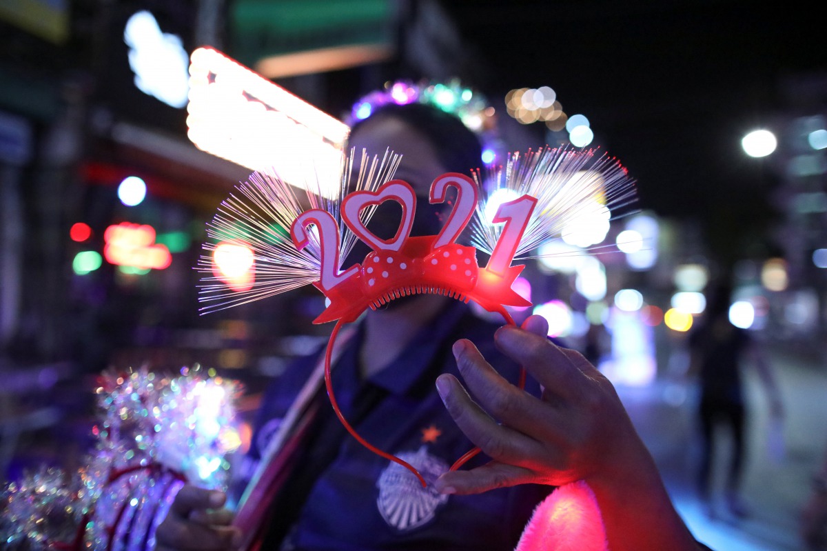 A woman sells a 2021 decoration at a popular entertainment street on New Year's Eve during the coronavirus disease (COVID-19) outbreak, in Bangkok, Thailand December 31, 2020. REUTERS/Soe Zeya Tun
