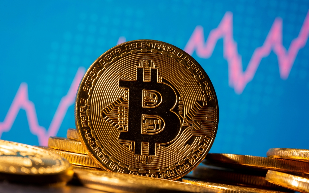 FILE PHOTO: A representation of virtual currency Bitcoin is seen in front of a stock graph in this illustration taken November 19, 2020. REUTERS/Dado Ruvic/Illustration