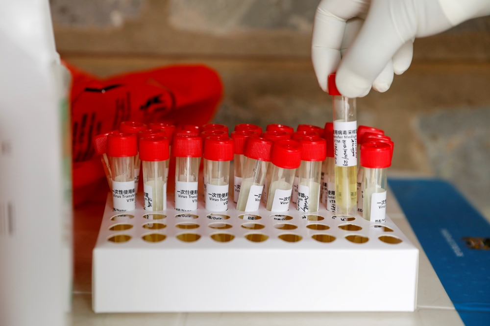 FILE PHOTO: A health worker holds a tube containing a sample during free mass testing for the coronavirus disease (COVID-19) in Kibera slums of Nairobi, Kenya, October 17, 2020. REUTERS/Baz Ratner
