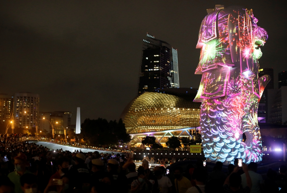 People watch a light show, as the traditional New Year's Eve fireworks are cancelled due to the coronavirus disease (COVID-19) outbreak, at Marina Bay in Singapore December 31, 2020. REUTERS/Edgar Su
