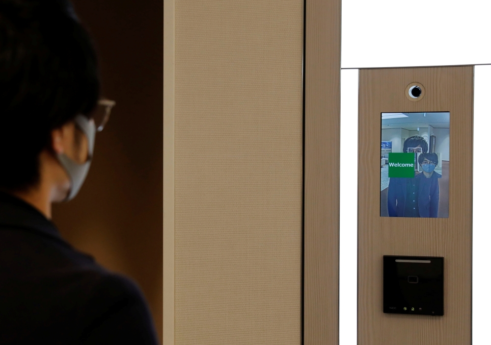 NEC's Shinya Takashima demonstrates a facial recognition system that identifies people even when they are wearing masks, at its headquarters in Tokyo, Japan, January 6, 2021. Reuters/Kim Kyung-Hoon