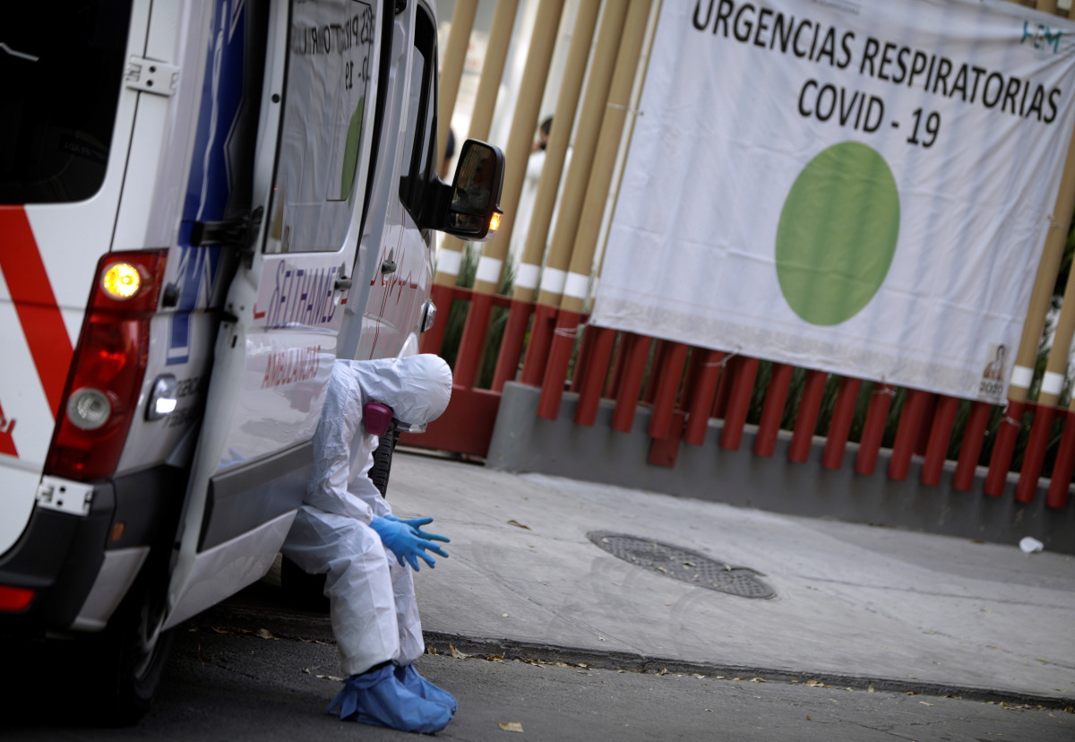 A paramedic waits outside the General Hospital for an available hospital bed for a patient showing symptoms of the coronavirus disease (COVID-19) to be admitted, in Mexico City, Mexico January 7, 2021. The sign reads 