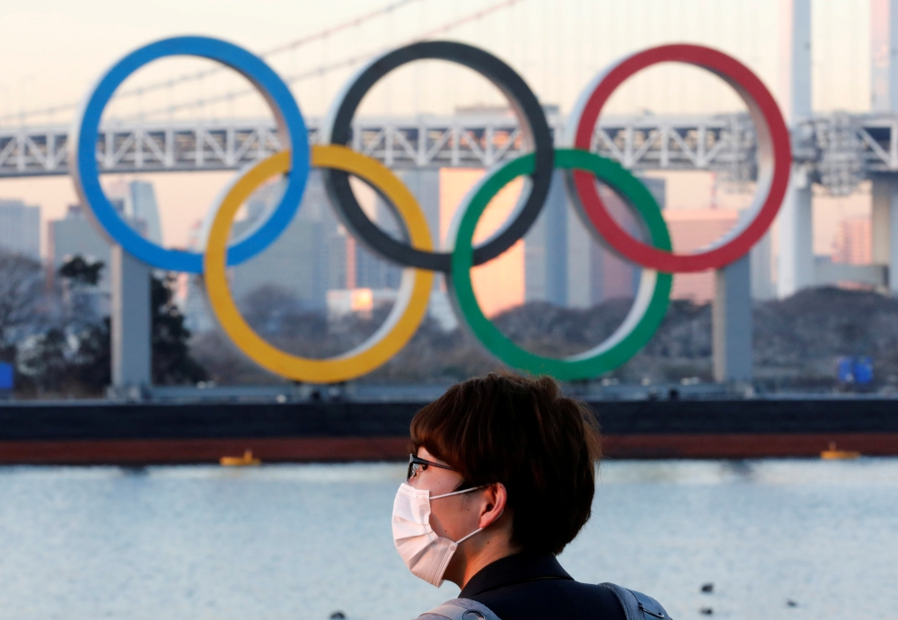 A man wears a protective mask amid the coronavirus disease (COVID-19) outbreak in front of the giant Olympic rings in Tokyo, Japan, January 13, 2021. REUTERS/Kim Kyung-Hoon/File Photo