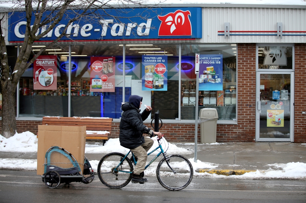 A man cycles past a Couche-Tard convenience store in Montreal, Quebec, Canada January 13, 2021. Reuters/Christinne Muschi/File Photo
