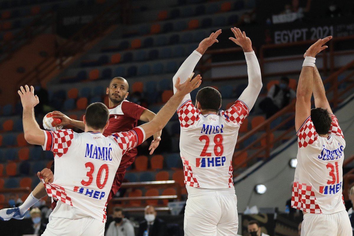 A Qatari player takes aim at the goal against three Croatian players during the final Group C match at the 27th IHF Men’s Handball World Championship - Egypt 2021 in Alexandria, yesterday.