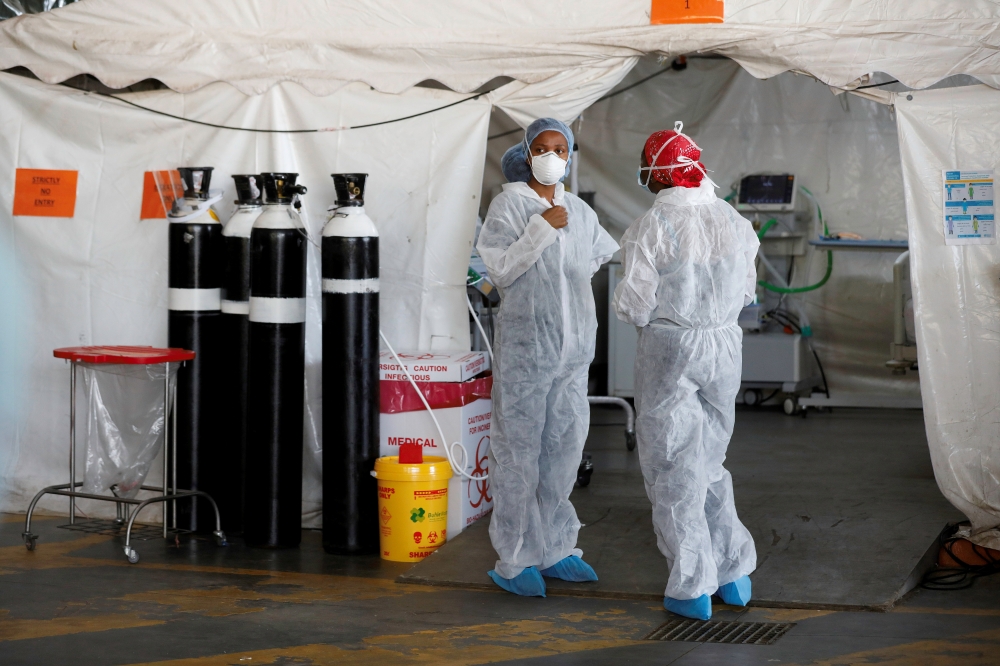 Healthcare workers chat at a temporary ward set up during the coronavirus disease (COVID-19) outbreak, at Steve Biko Academic Hospital in Pretoria, South Africa, January 19, 2021. Phill Magakoe/Pool via Reuters/File Photo
