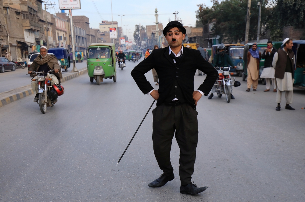 Usman Khan, 29, dressed up as Charlie Chaplin, performs along the street in Peshawar, Pakistan January 27, 2021. Picture taken January 27, 2021. Reuters/Fayaz Aziz