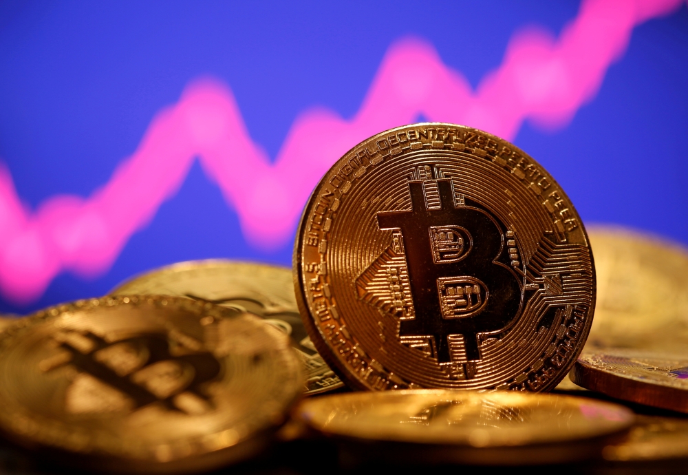 FILE PHOTO: A representation of virtual currency Bitcoin is seen in front of a stock graph in this illustration taken January 8, 2021. REUTERS/Dado Ruvic