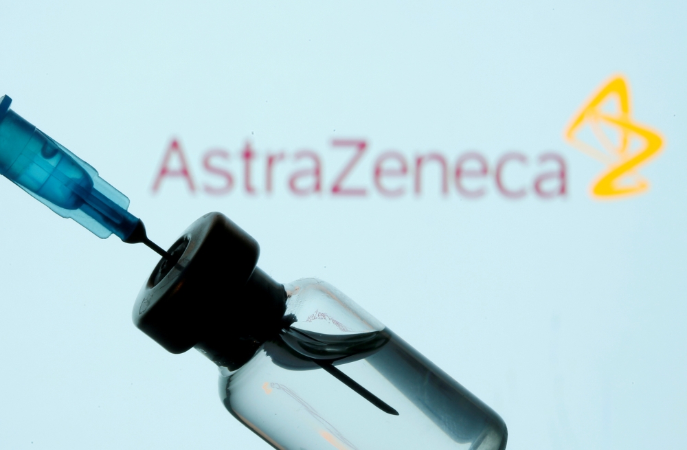 A vial and sryinge are seen in front of a displayed AstraZeneca logo in this illustration taken January 11, 2021. REUTERS/Dado Ruvic/Illustration/File Photo/File Photo