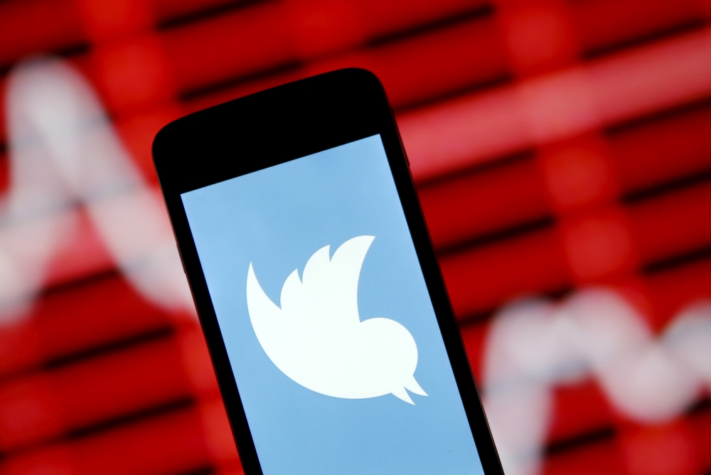 The Twitter logo is shown on smartphone in front of a displayed stock graph in central Bosnian town of Zenica, Bosnia and Herzegovina, in this April 29, 2015 photo illustration. REUTERS/Dado Ruvic/File Photo
