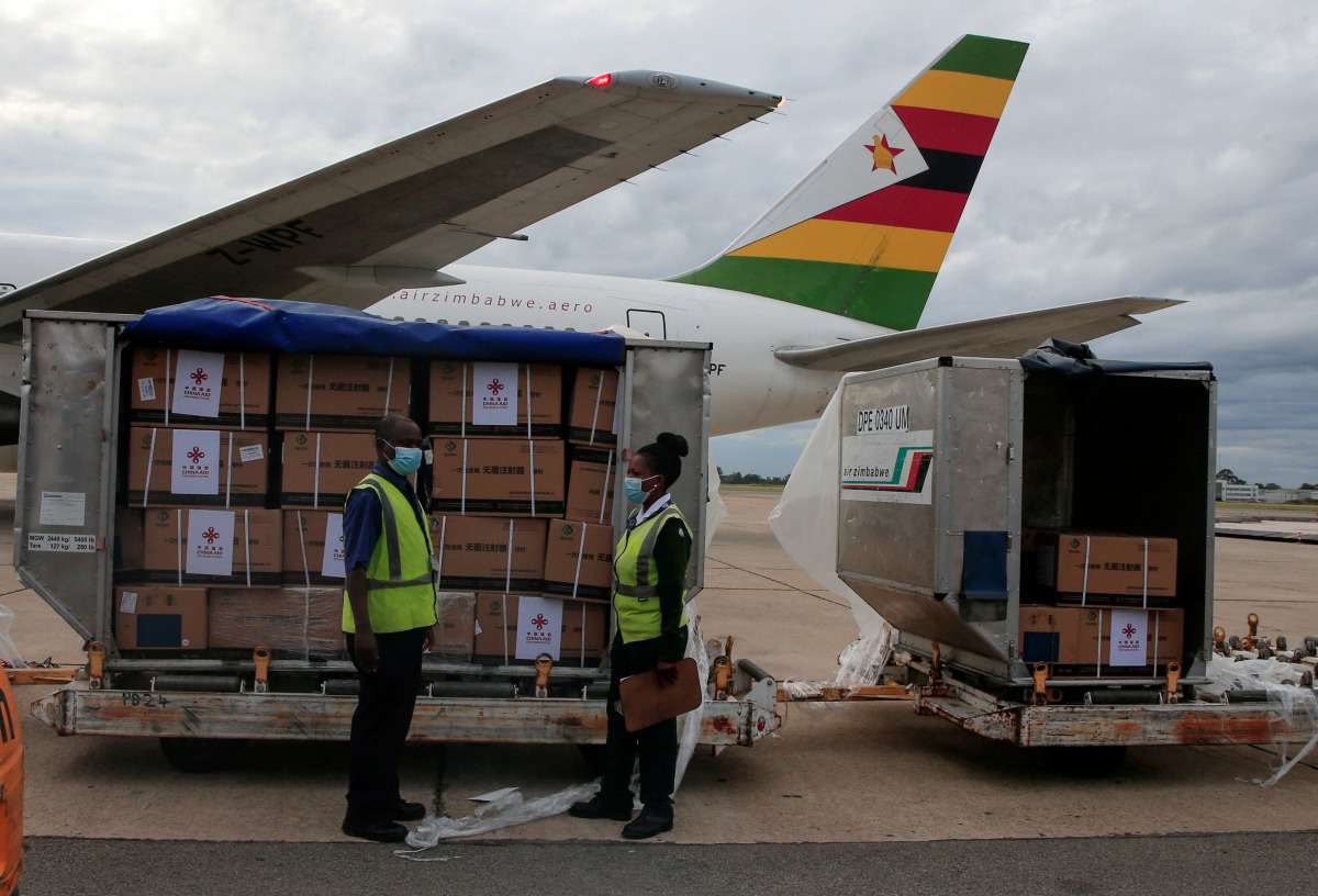 FILE PHOTO: Workers offload boxes as Zimbabwe's first batch of coronavirus disease (COVID-19) vaccines arrives from China, in Harare, Zimbabwe, February 15,2021. REUTERS/Philimon Bulawayo/File Photo
