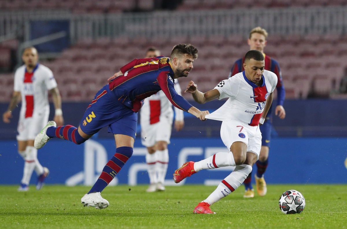 Soccer Football - Champions League - Round of 16 First Leg - FC Barcelona v Paris St Germain - Camp Nou, Barcelona, Spain - February 16, 2021 Paris St Germain's Kylian Mbappe in action with Barcelona's Gerard Pique REUTERS/Albert Gea
