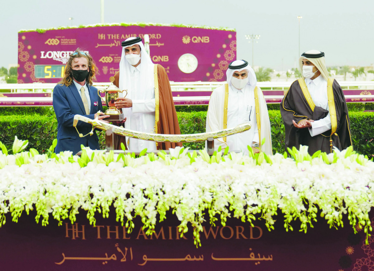 The Amir H H Sheikh Tamim bin Hamad Al Thani presenting a trophy to trainer Julian Smart after Mon’nia won the prestigious Amir Sword at Al Rayyan Park yesterday. 
