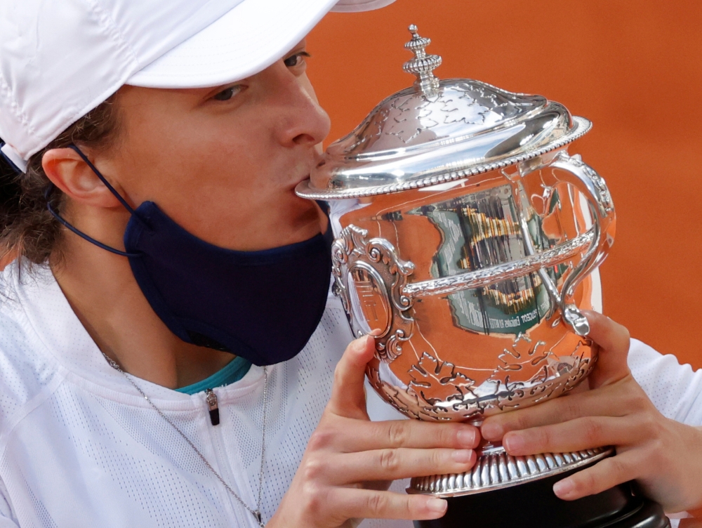 Poland's Iga Swiatek kisses the trophy as she celebrates after winning the French Open. REUTERS/Christian Hartmann/File Photo