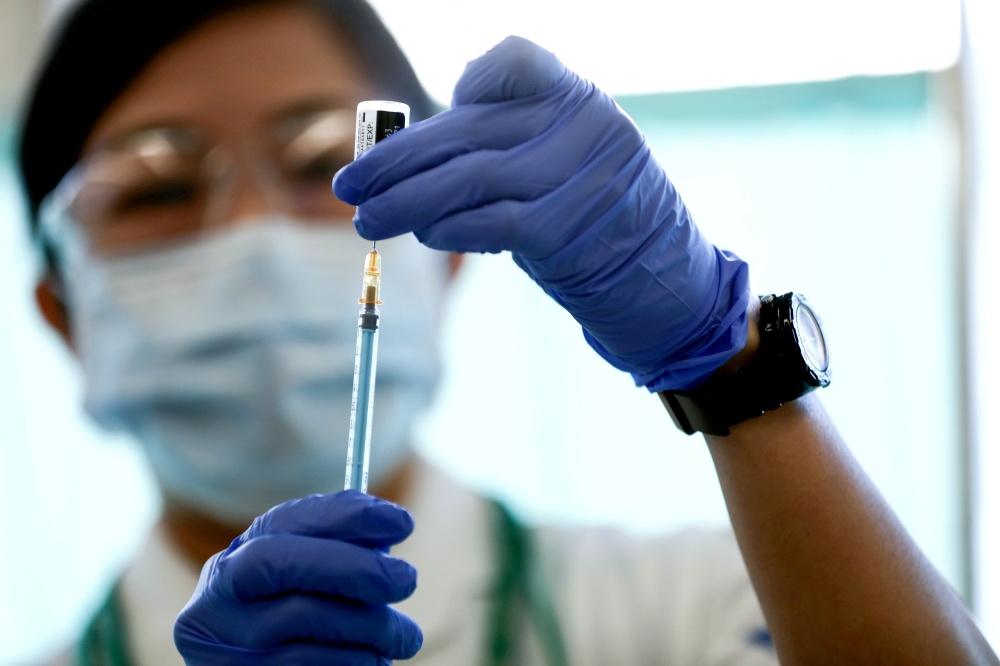 A medical worker fills a syringe with a dose of the Pfizer-BioNTech coronavirus disease (COVID-19) vaccine as Japan launches its inoculation campaign, at Tokyo Medical Center in Tokyo, Japan February 17, 2021. Behrouz Mehri/Pool via REUTERS/File Photo