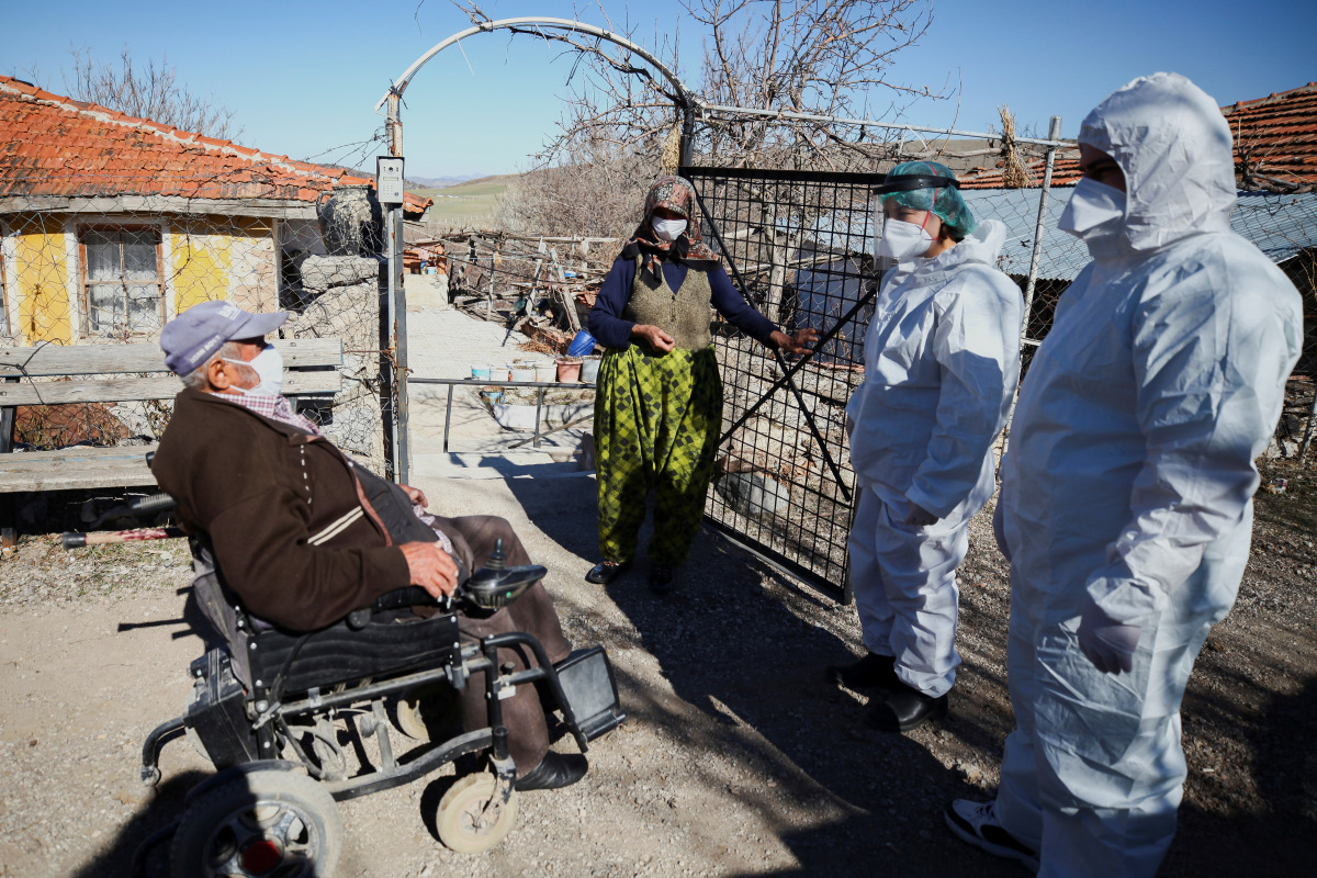 Health workers chat with Hakki Karakaya and his wife Ferdane Karakaya, an elderly couple living in Deliler village near Elmadag, after administering the Sinovac's CoronaVac COVID-19 vaccine at their home as nationwide vaccination continues for seniors, in