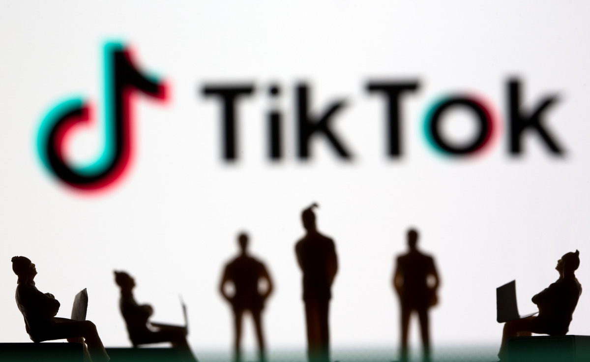 Small toy figures are seen in front of TikTok logo in this illustration picture taken March 15, 2021. REUTERS/Dado Ruvic/Illustration
