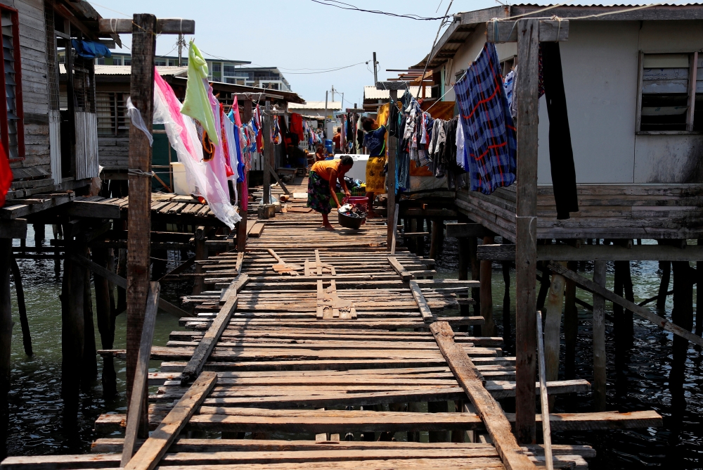 File photo: A woman washes clothes on a wooden path between stilt houses at Hanuabada Village, located in Port Moresby Harbour, Papua New Guinea, November 19, 2018. Reuters/David Gray/File Photo