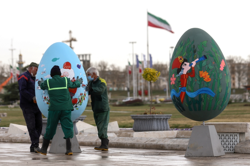 Municipality personnel carry Nowruz-themed decorations, ahead of Nowruz, the Iranian New Year, amid the coronavirus disease (COVID-19) pandemic, in Tehran, Iran March 17, 2021. Picture taken March 17, 2021. Majid Asgaripour/WANA