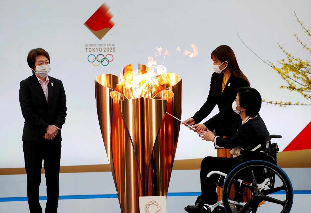 FILE PHOTO: Tokyo 2020 President Seiko Hashimoto looks on as actor Satomi Ishihara and Paralympian Aki Taguchi light the celebration cauldron on the first day of the Tokyo 2020 Olympic torch relay in Naraha, Fukushima prefecture, Japan March 25, 2021. REU