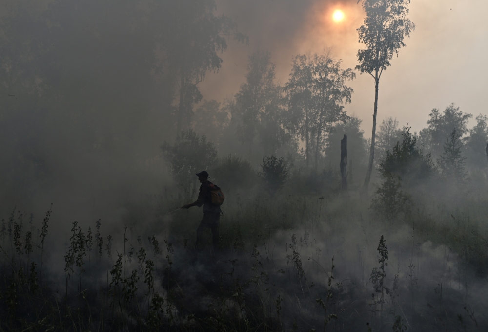 File photo: A specialist of the Russian Federal Agency for Forestry works to put out a forest fire outside the village of Basly in Omsk Region, Russia August 11, 2020. REUTERS/Alexey Malgavko/File Photo
