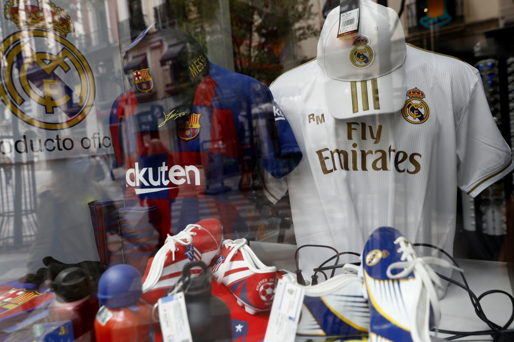 Barcelona, Real Madrid and Atletico Madrid merchandise is seen through a shop window as twelve of Europe's top football clubs launch a breakaway REUTERS/Susana Vera
