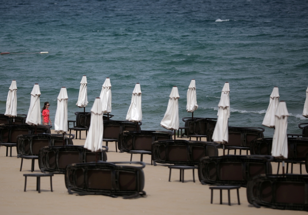 A tourist walks near empty sunbeds at Sunny Beach resort on the Black Sea, Bulgaria June 23, 2020. Picture taken June 23, 2020. REUTERS/Stoyan Nenov/File Photo