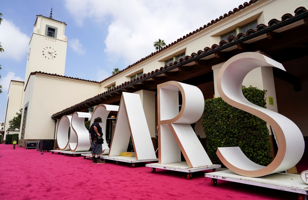 A crew member looks over a background element for the red carpet at Union Station, one of the locations for the 93rd Academy Awards in Los Angeles, California, U.S. April 24, 2021. Picture taken April 24, 2021. Chris Pizzello/Pool via REUTERS