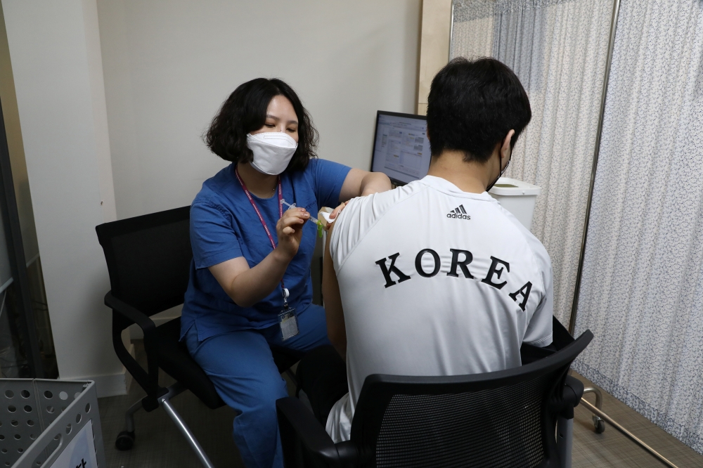 South Korean Olympic judo team player An Ba-ul receives the first dose of the Pfizer-BioNTech coronavirus vaccine at the National Medical Center in Seoul, South Korea April 29, 2021. Chung Sung-Jun/Pool via REUTERS
