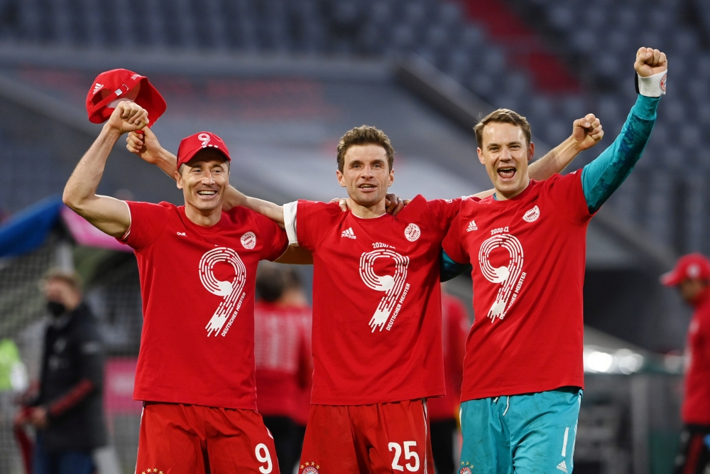 Bayern Munich's Thomas Muller, Manuel Neuer and Robert Lewandowski celebrate after the match after winning the Bundesliga. (REUTERS/Christof Stache)